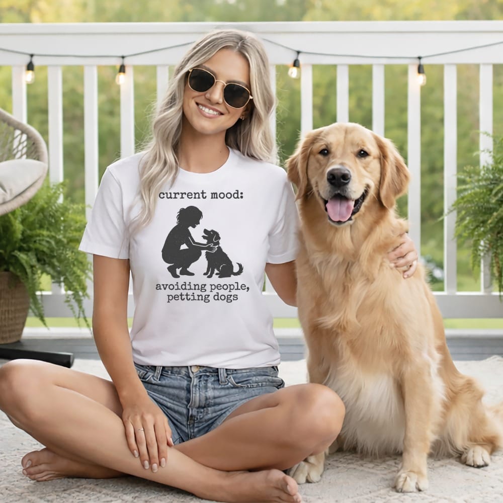 Woman wearing t-shirt with text "current mood: avoiding people, petting dogs" with a golden retriever.