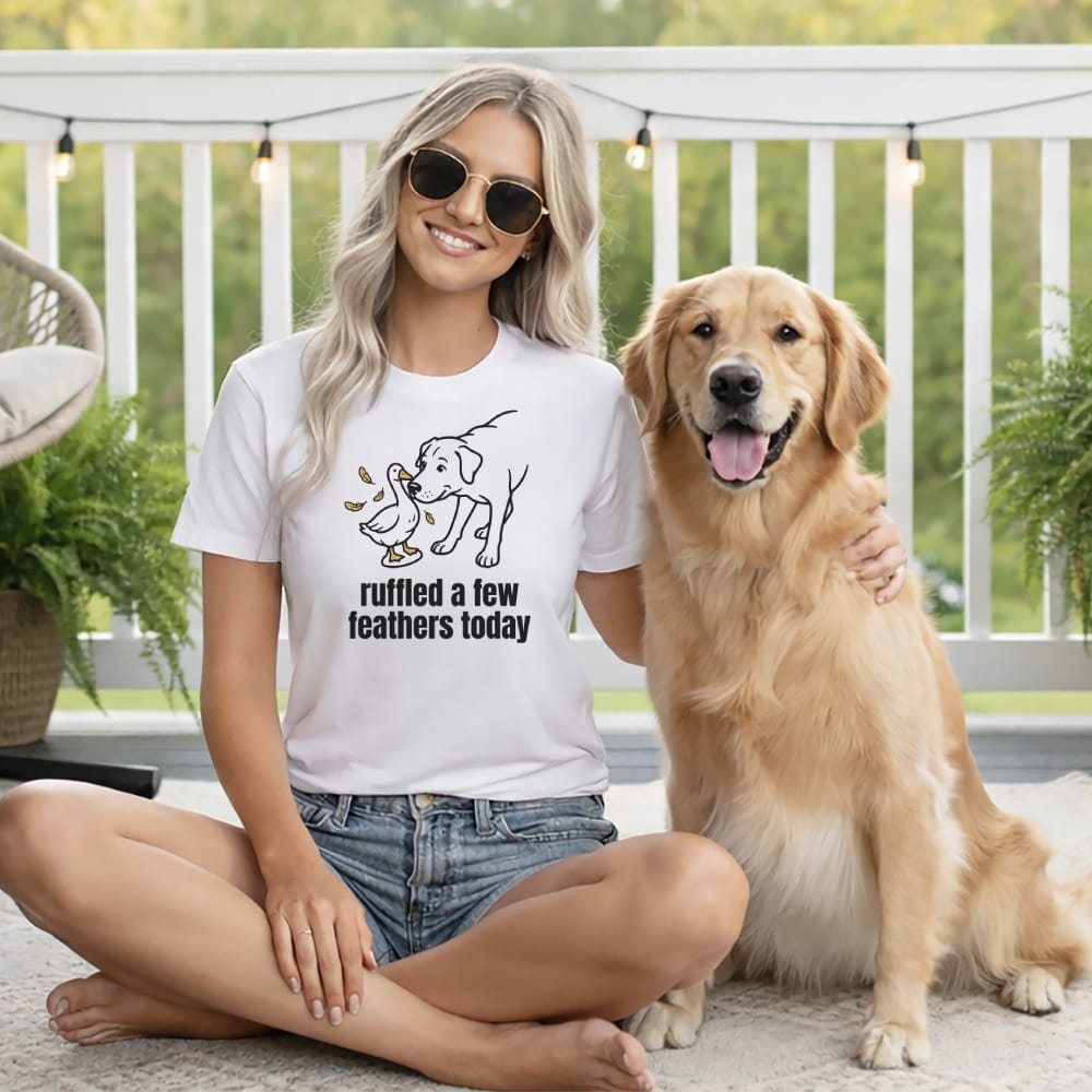 Woman in white t-shirt with dog and duck graphic, text reads "ruffled a few feathers today."