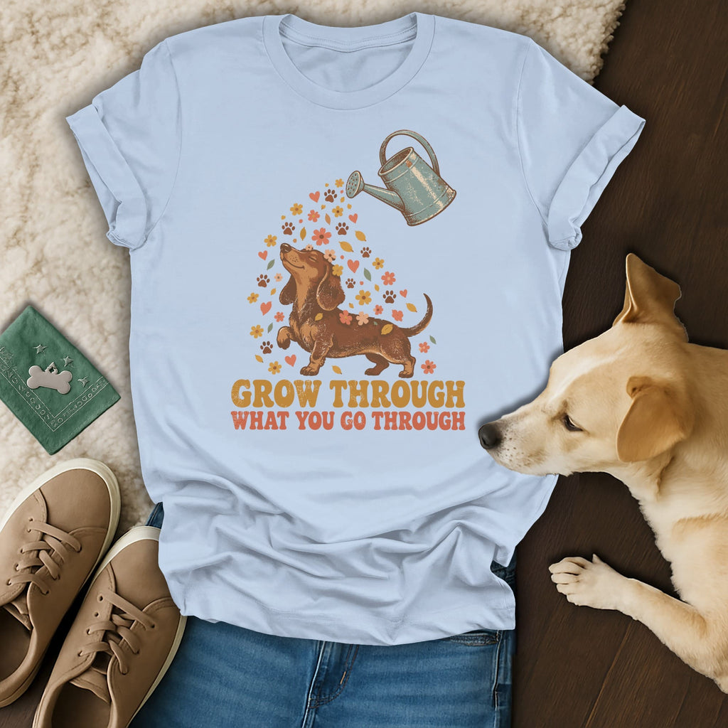 Light blue t-shirt featuring a dachshund graphic and the text GROW THROUGH WHAT YOU GO THROUGH.