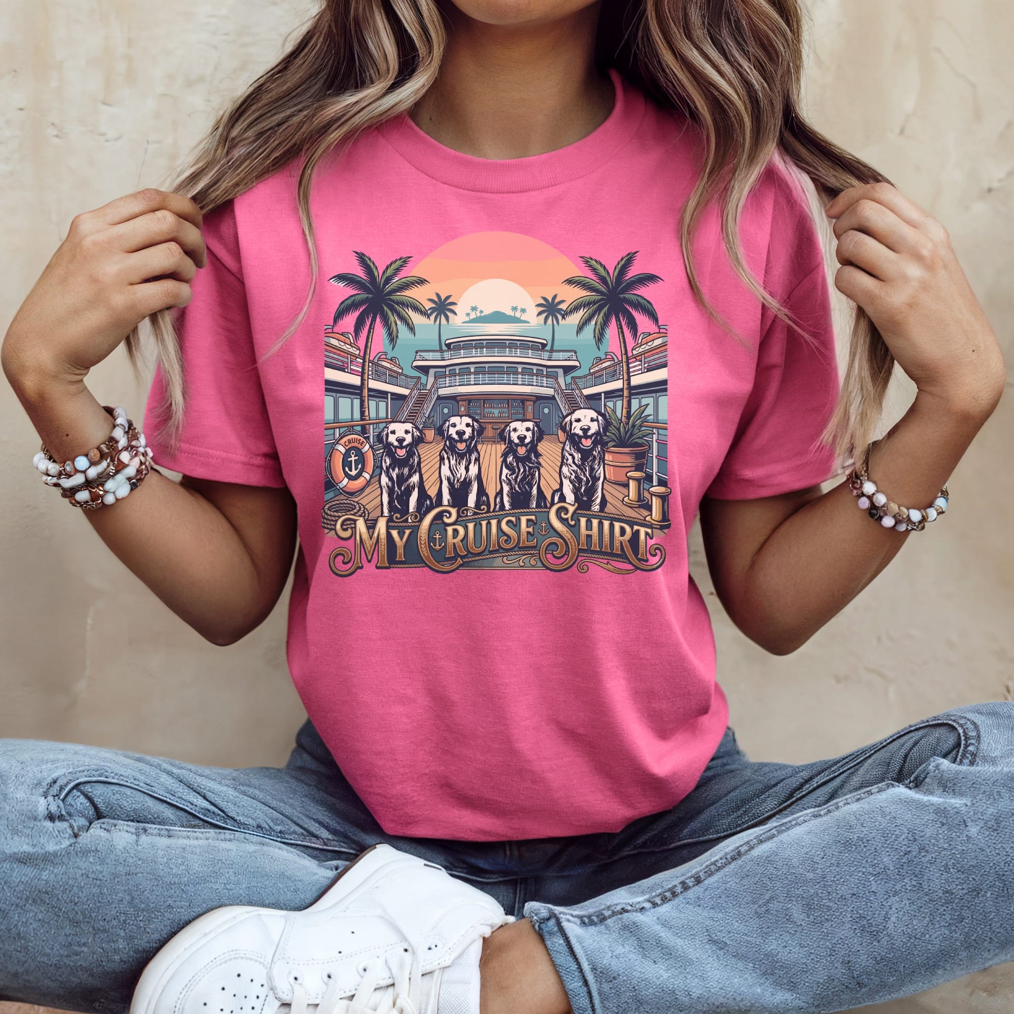 Pink t-shirt with graphic of dogs on a cruise ship deck with palm trees.