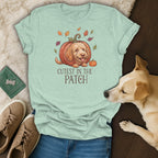 Light blue t-shirt with a cartoon dog inside a pumpkin and the text "Cutest in the Patch".