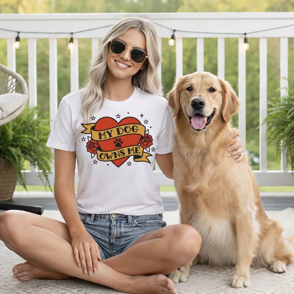 Woman wearing a t-shirt that says "My Dog Owns Me" with a dog.