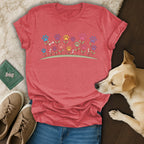 Red t-shirt with colorful dog paw print flowers and bone stems.