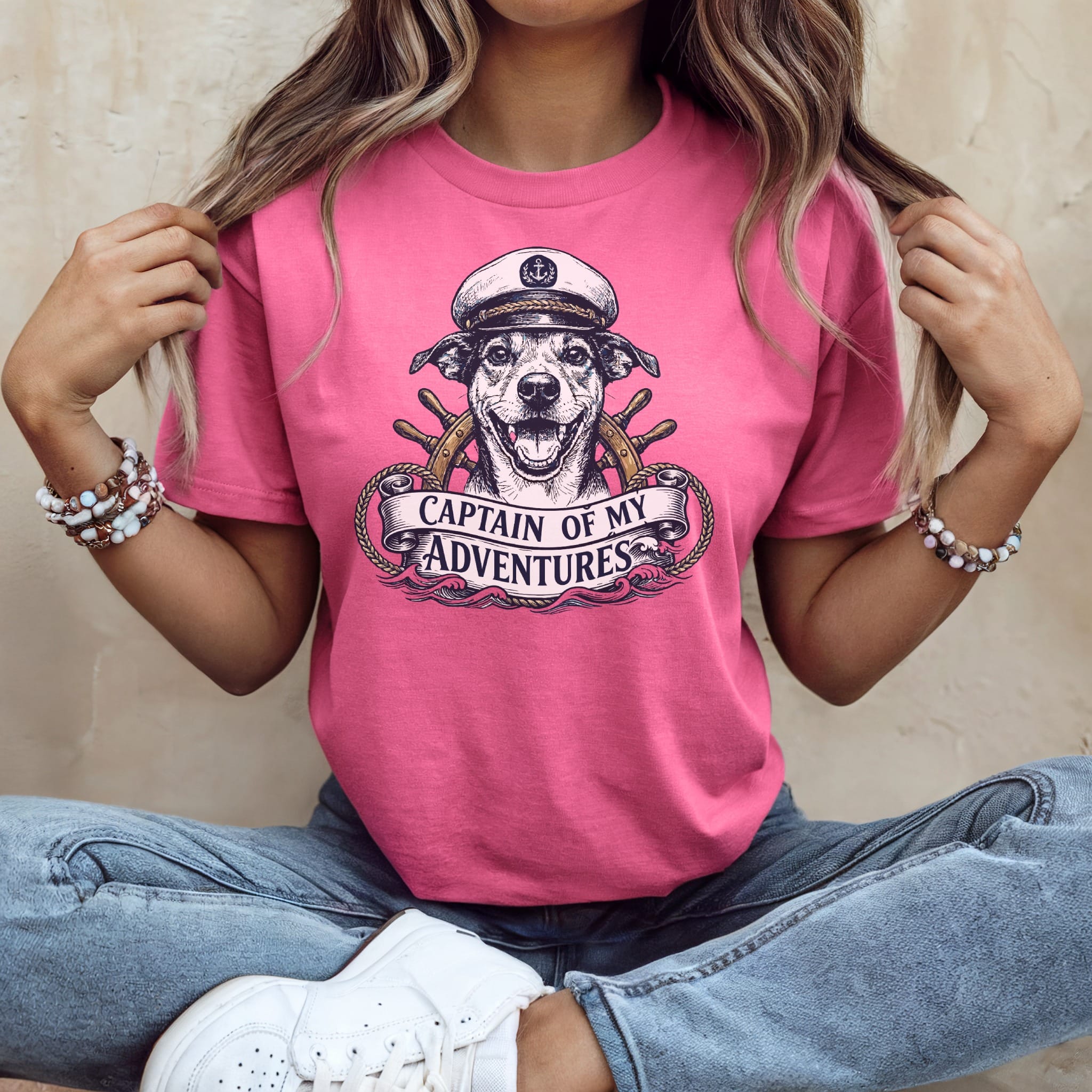 Pink t-shirt with a graphic of a dog wearing a captain's hat and steering wheel.