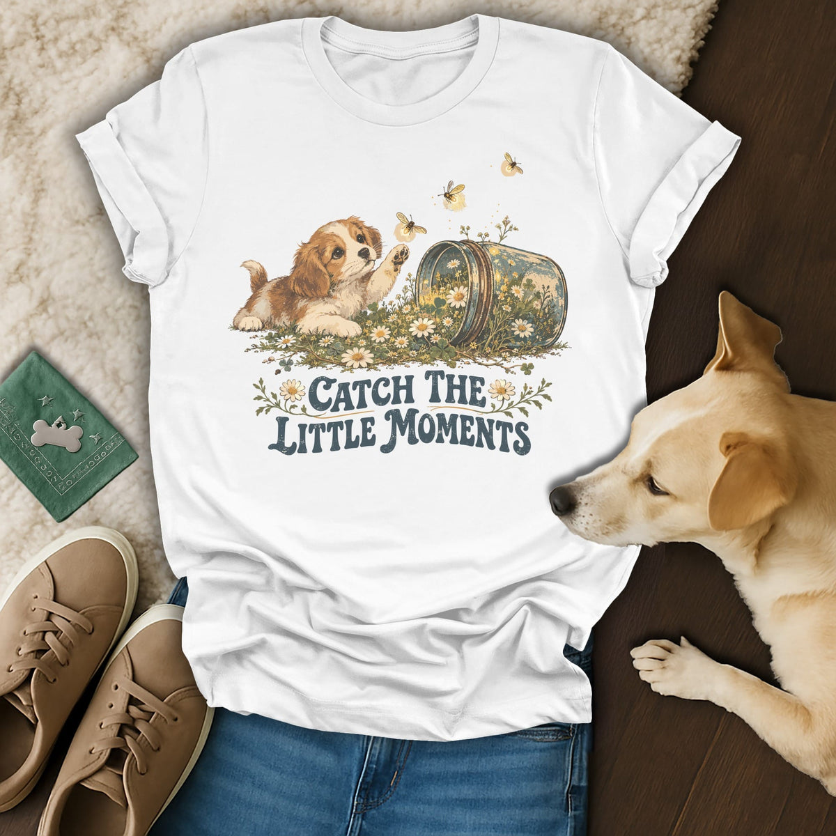 A white t-shirt featuring a puppy reaching for a butterfly, with the text Catch The Little Moments.