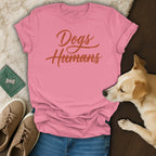 Pink t-shirt with "Dogs Humans" in orange cursive text.