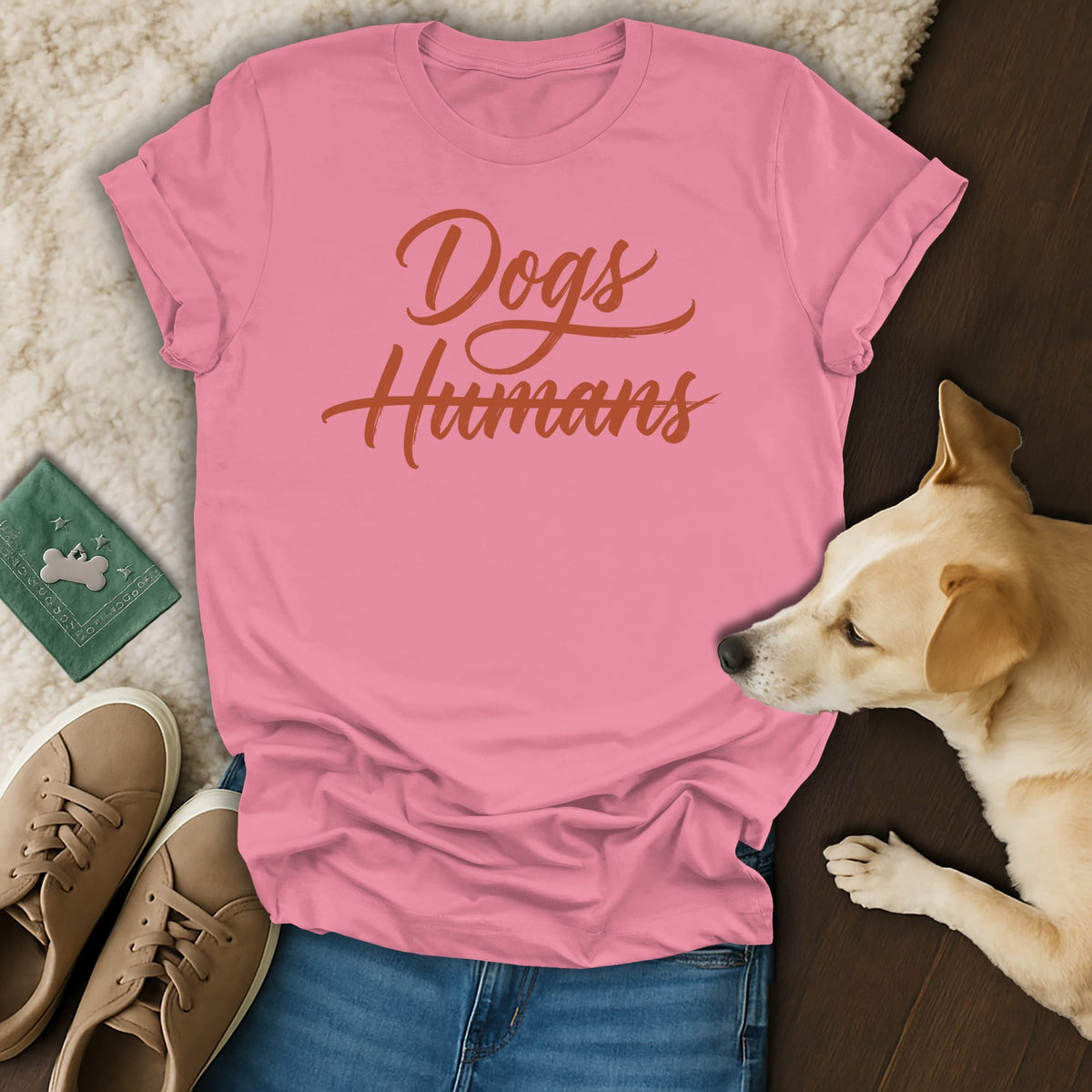 Pink t-shirt with "Dogs Humans" in orange cursive text.