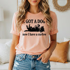 Peach t-shirt with black text and dog graphic: "I GOT A DOG now I have a curfew"