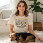 Woman wearing "Dog Park World Tour" t-shirt with cartoon dogs at a park.