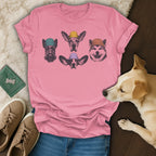 Pink t-shirt with four sketched dog faces wearing beanies.