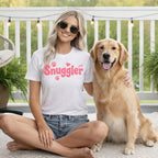 Woman in "Snuggler" t-shirt sitting with golden retriever on porch.