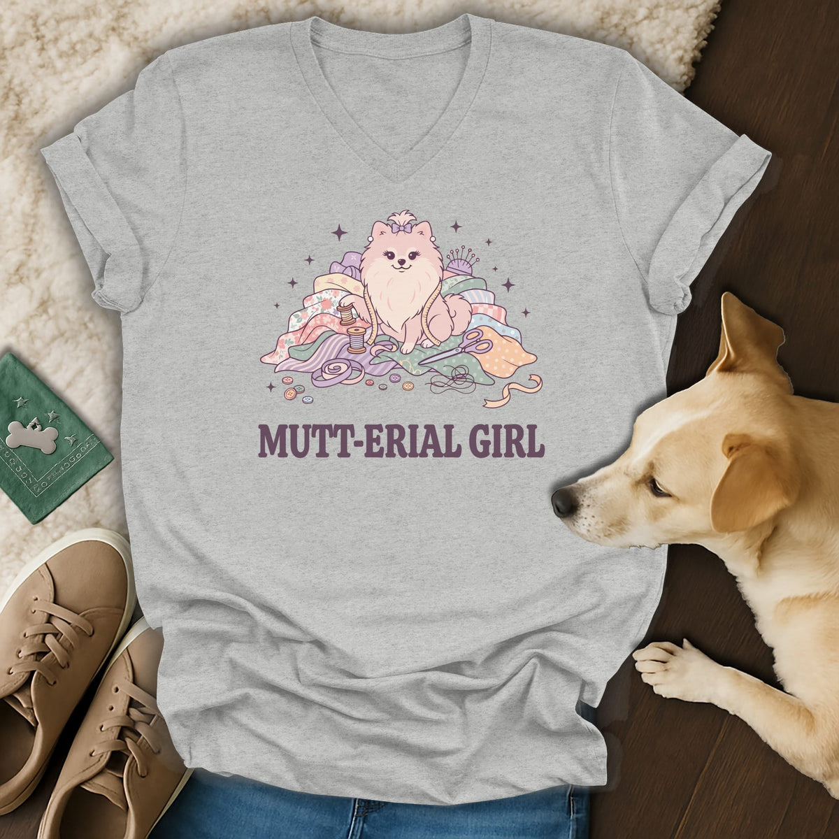 Grey t-shirt with a Pomeranian dog sitting on fabric scraps, with text "MUTT-ERIAL GIRL".