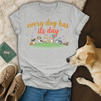 Grey t-shirt with cartoon dogs and "every dog has its day" text.