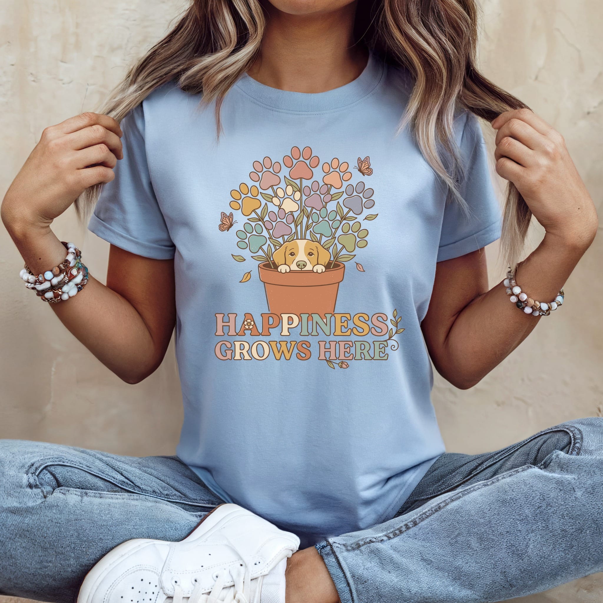 Dog in flower pot with paw prints and text "HAPPINESS GROWS HERE".