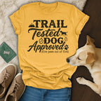 Yellow t-shirt with "Trail Tested Dog Approved (five paws out of five)" text and dog graphic.