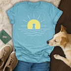 Blue t-shirt with a minimalist sun, sea, and dog graphic.