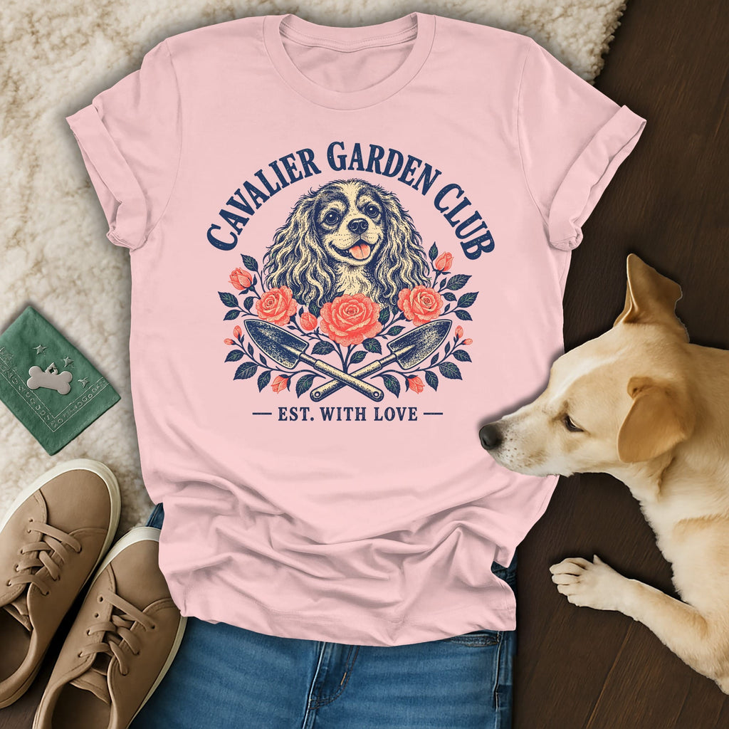 Pink t-shirt with a Cavalier Garden Club graphic featuring a spaniel, roses, and crossed garden trowels.