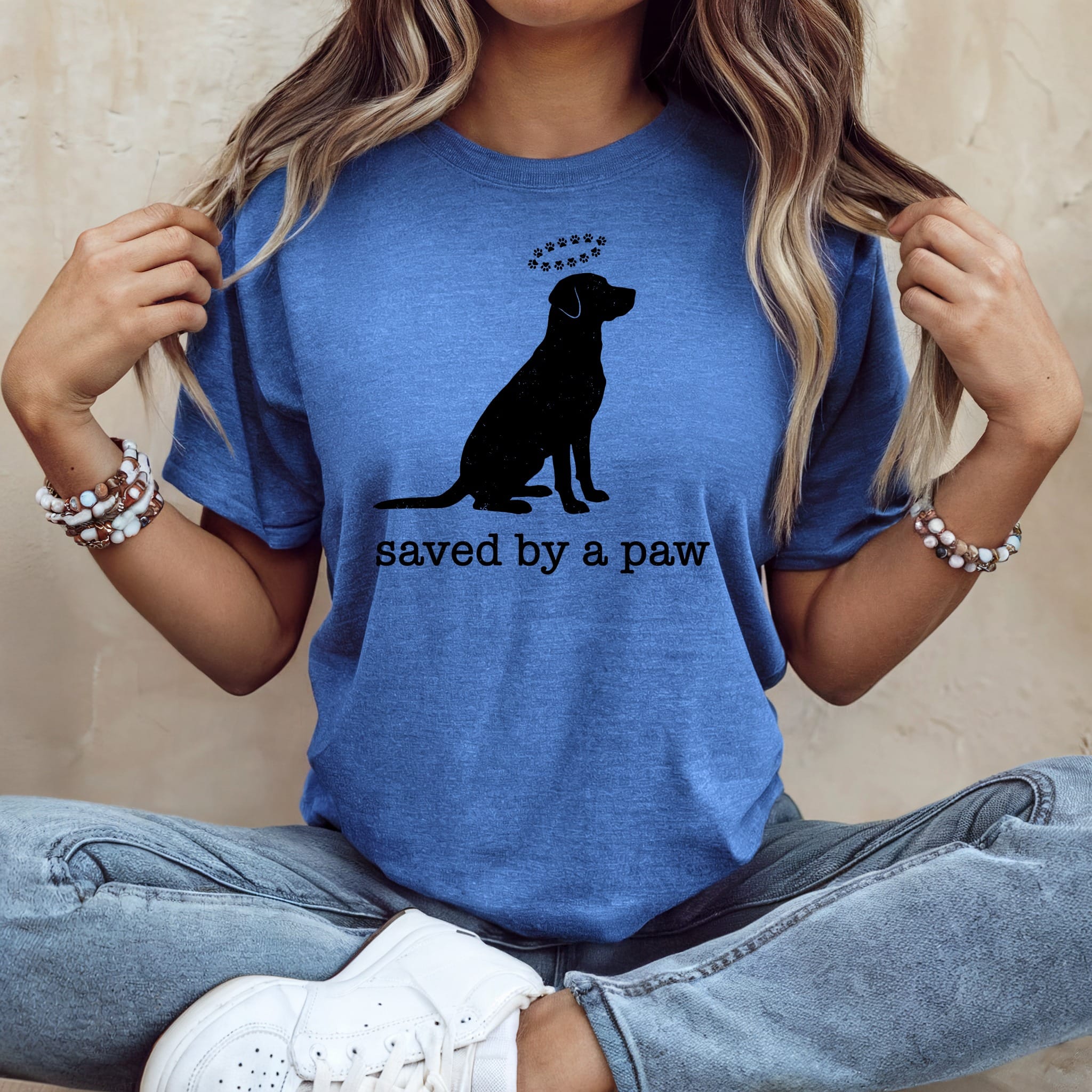 Blue t-shirt with black silhouette of a dog and "saved by a paw" text.