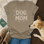Tan t-shirt with "DOG MOM" text designed with shells and paw prints.