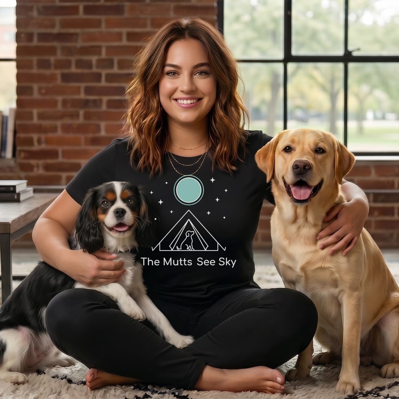 Woman with two dogs wearing a "The Mutts See" t-shirt.