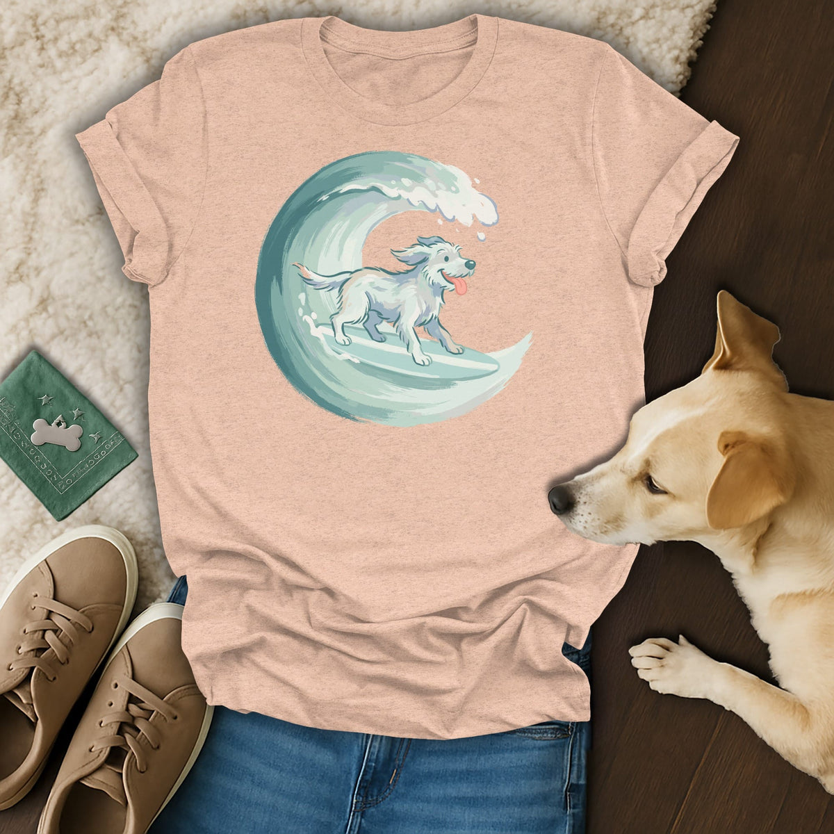 Peach t-shirt with a white dog surfing on a turquoise wave graphic.