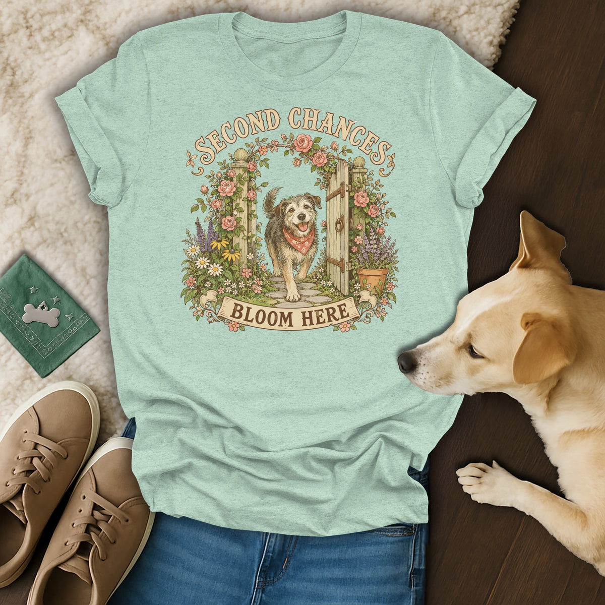 Light green t-shirt with a vintage illustration of a dog, flowers, and the text Second Chances Bloom Here.