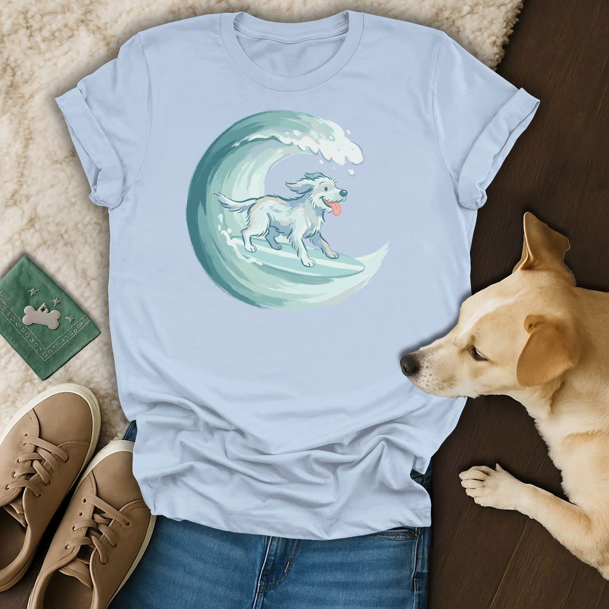 Light blue t-shirt with illustration of a white dog surfing a wave.