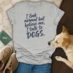 Light grey t-shirt with navy blue text reading "I look normal but believe me, I talk to DOGS."
