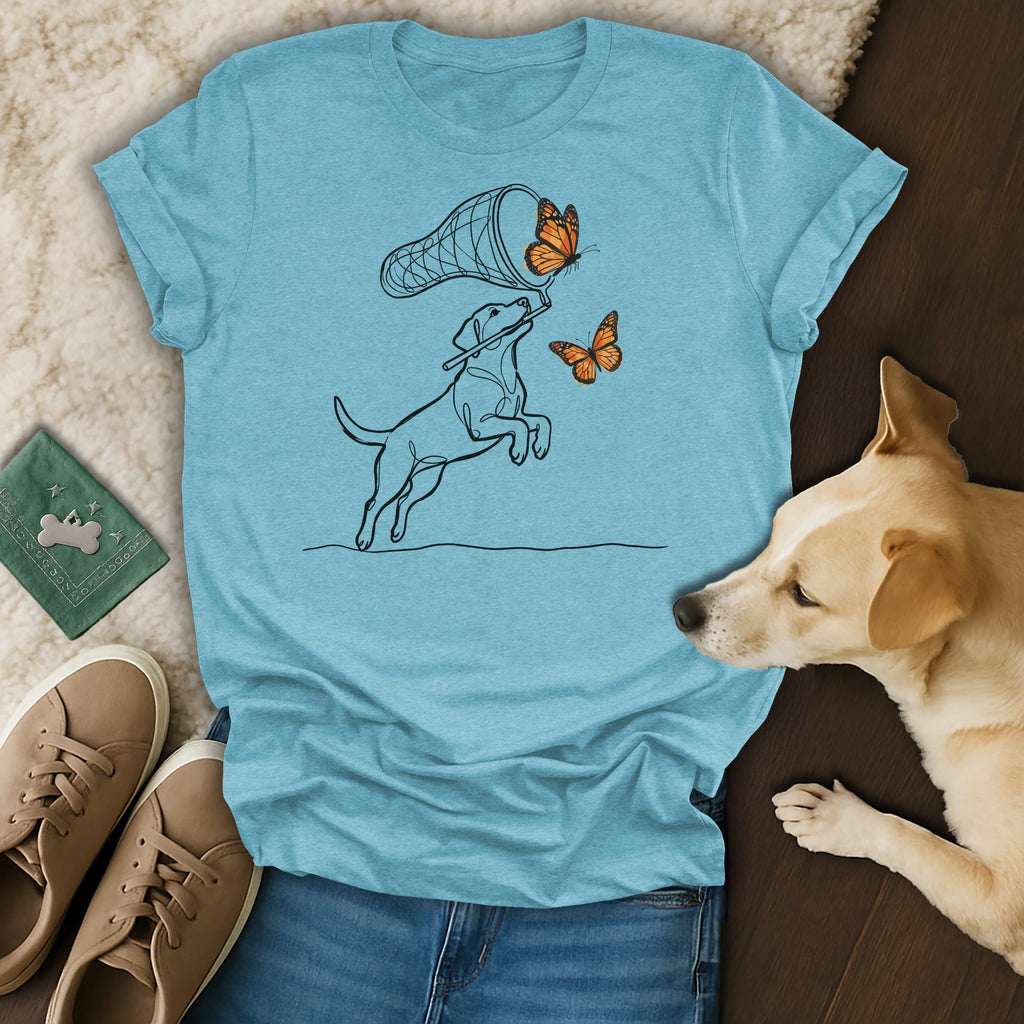 Dog leaping to catch butterflies with net on blue t-shirt.