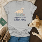Grey t-shirt with illustration of dog in boots with text "supposed to be GARDENING".