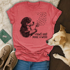 T-shirt with dog blowing dandelion seeds with paw prints.