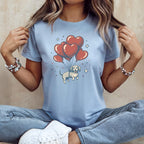Light blue t-shirt with graphic of dachshund floating on heart-shaped balloons.