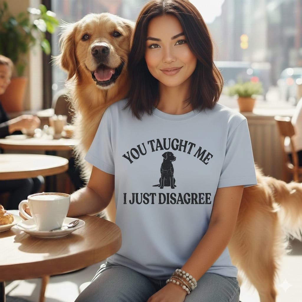 Woman in a t-shirt with text and dog in a cafe.