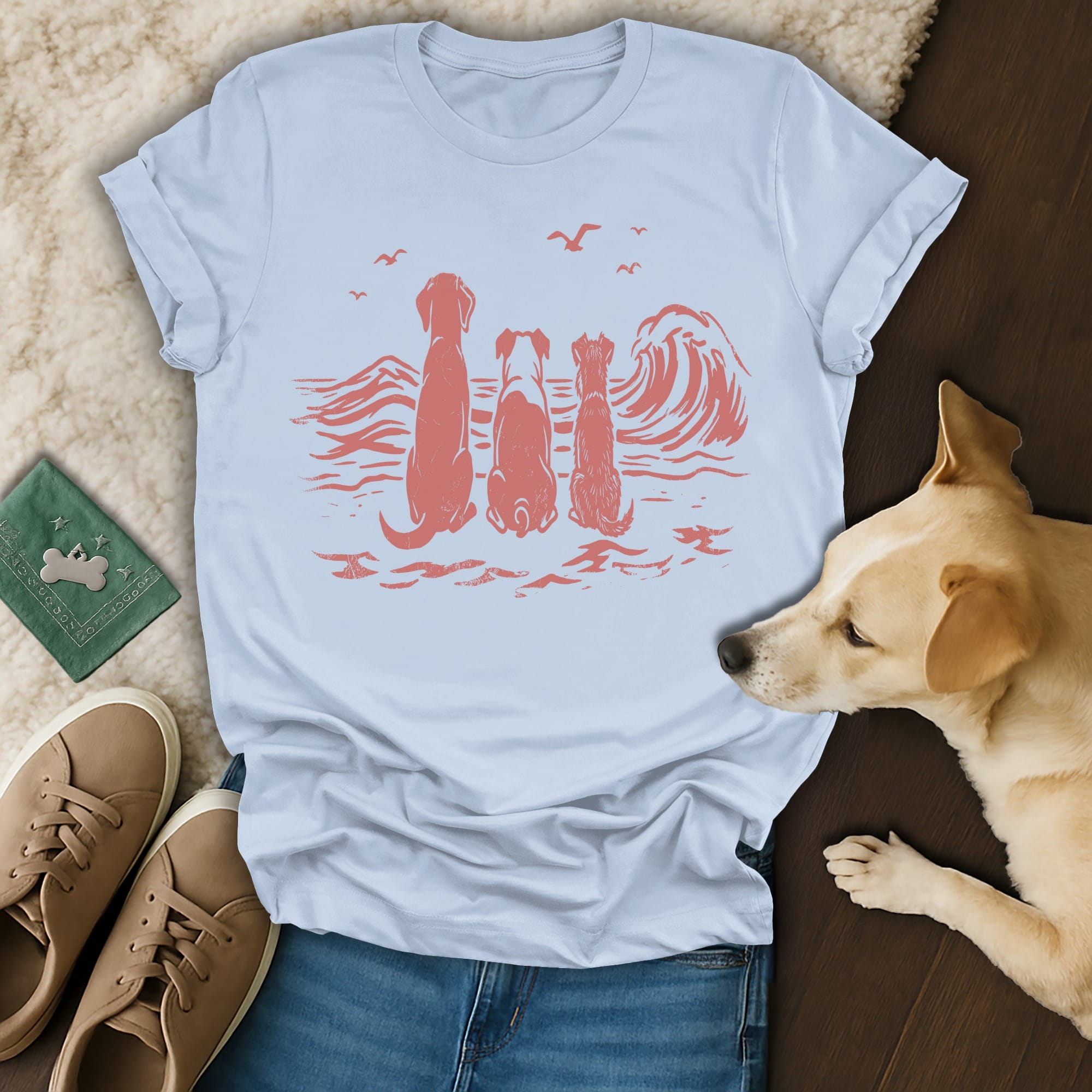 Four dogs silhouetted against a coral wave and seagulls on a light blue t-shirt.