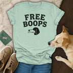 Light mint t-shirt with "FREE BOOPS" text and a dog illustration, beside a dog and sneakers.