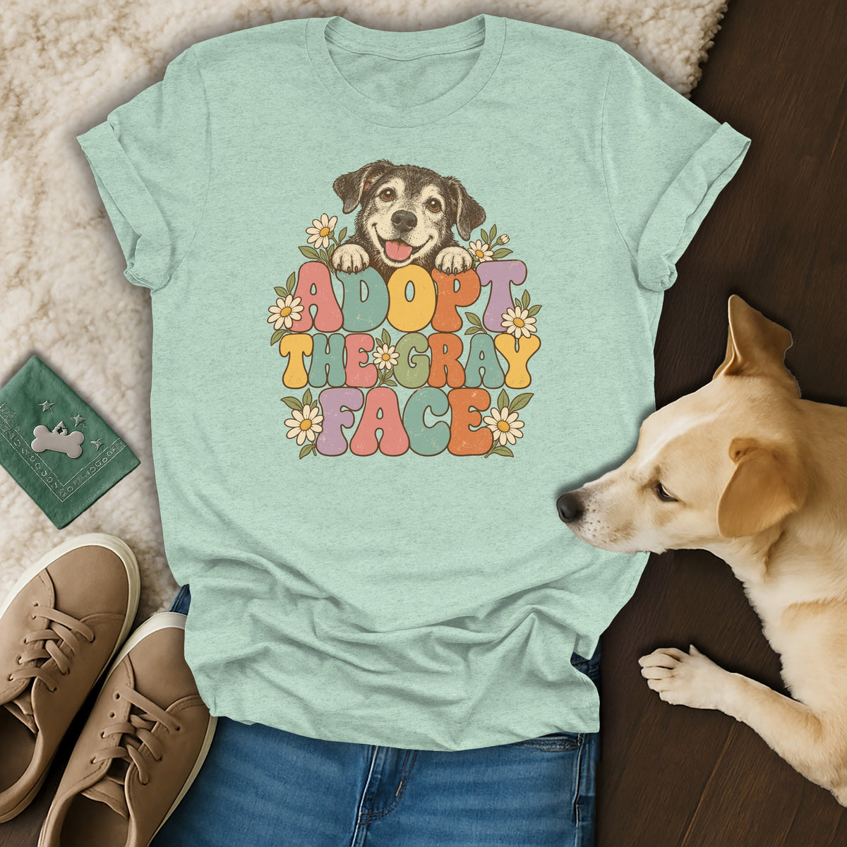 Light green t-shirt with retro "Adopt the Gray Face" dog graphic surrounded by daisies.