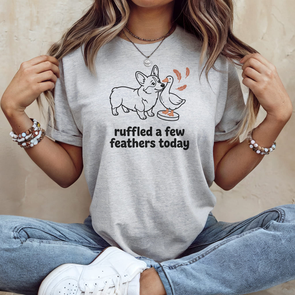 Light gray t-shirt with a line drawing of a corgi and duck with text "ruffled a few feathers today".