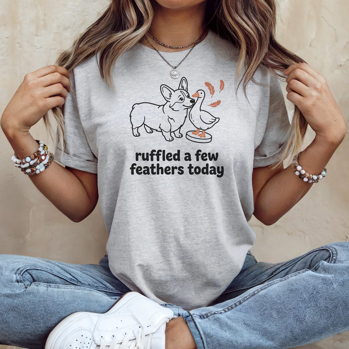 Light gray t-shirt with a line drawing of a corgi and duck with text "ruffled a few feathers today".