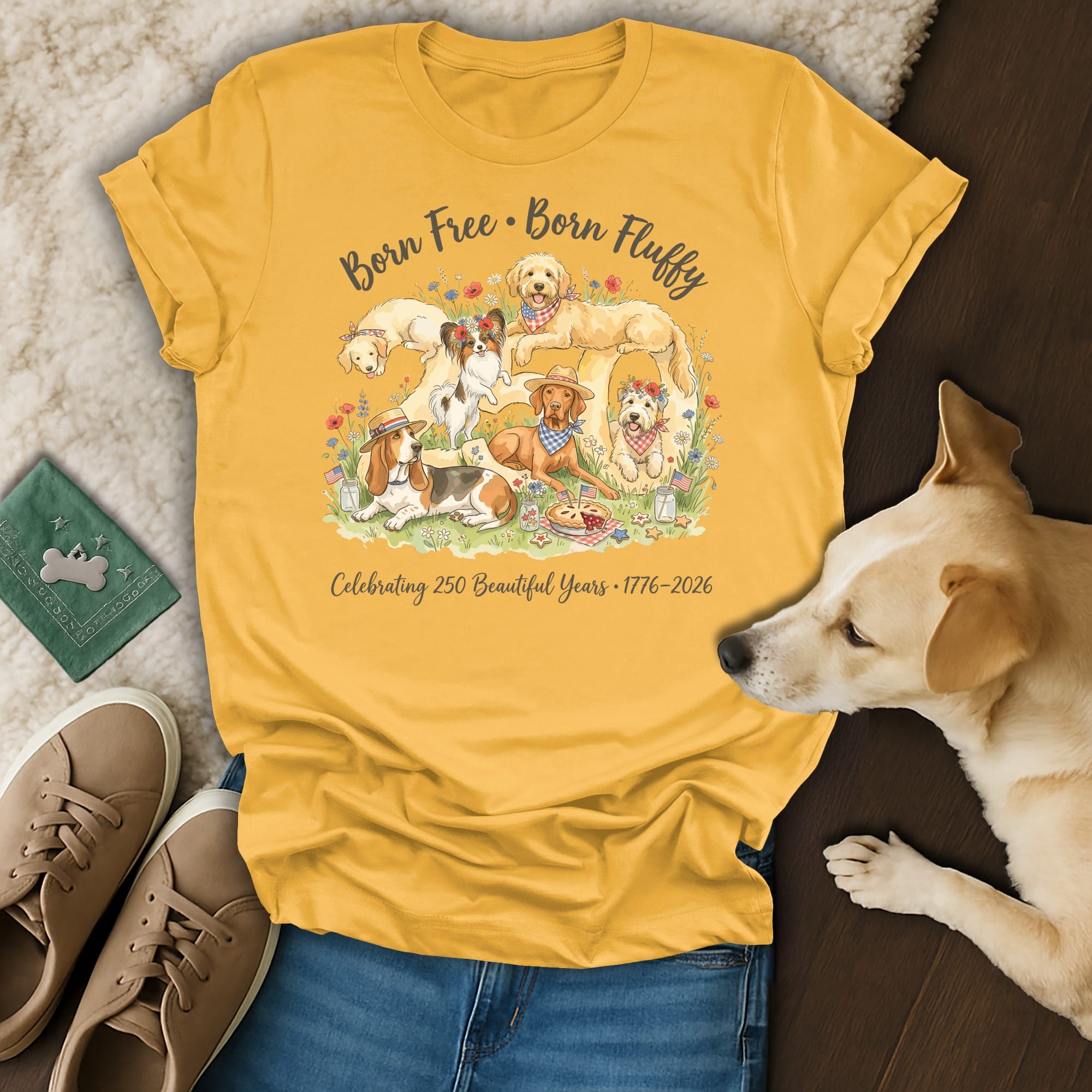 Yellow t-shirt with dogs, flowers, and "Born Free. Born Fluffy. Celebrating 250 Beautiful Years 1776-2026."