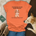 Orange t-shirt with a cartoon dog holding a teacup and text "I'm trying to be more social".