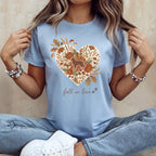Light blue t-shirt with heart graphic of dog, flowers, acorns, and mushrooms.