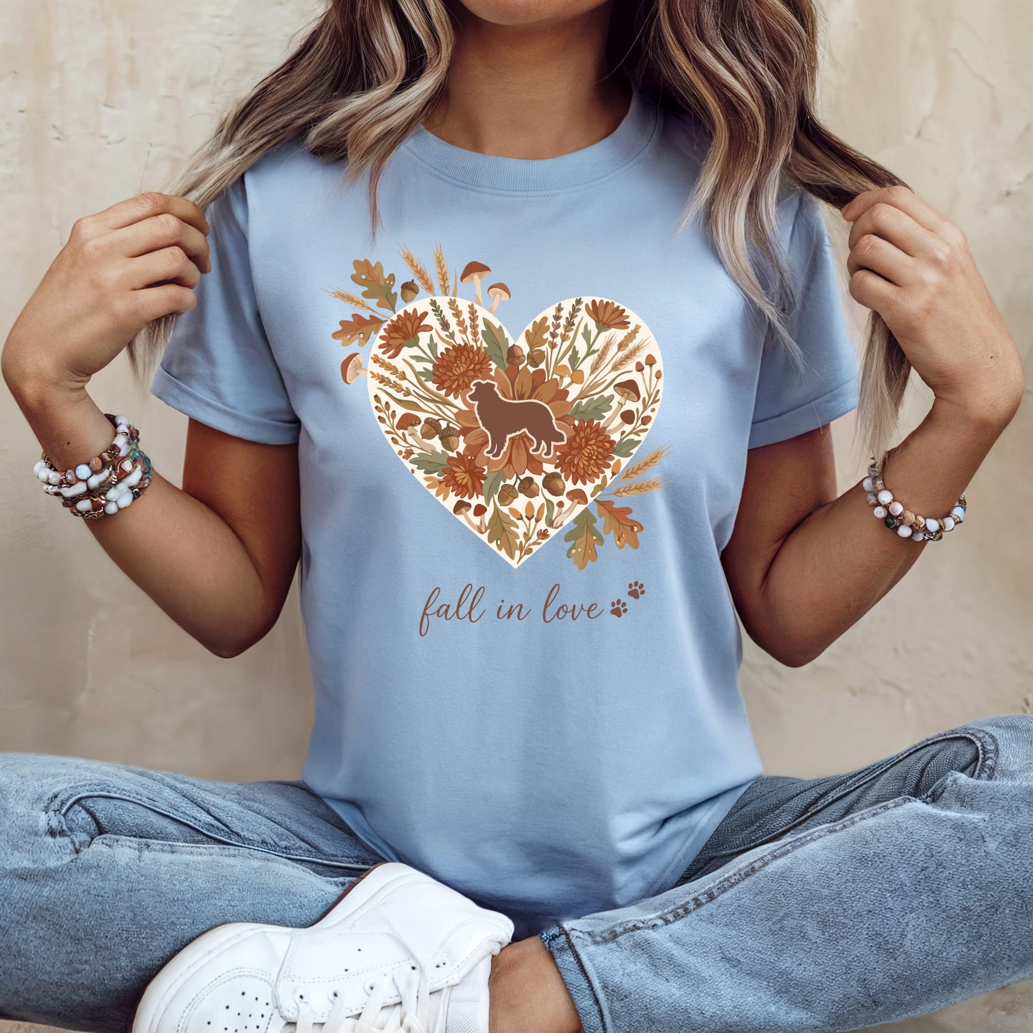Light blue t-shirt with heart graphic of dog, flowers, acorns, and mushrooms.