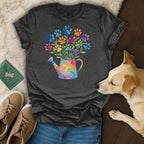 Dark gray t-shirt with a watercolor watering can and colorful paw print flowers.