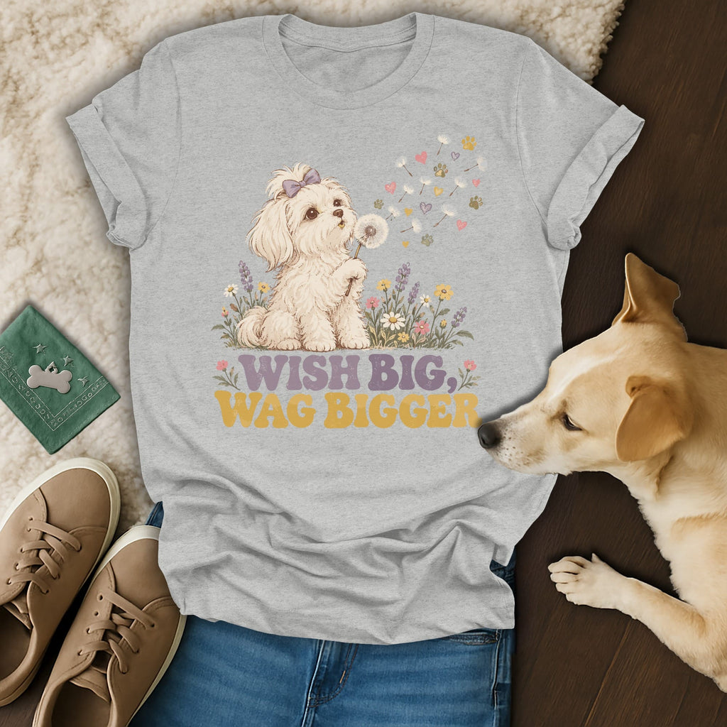 Heather gray t-shirt featuring a graphic of a puppy blowing dandelion seeds and the text Wish Big, Wag Bigger.