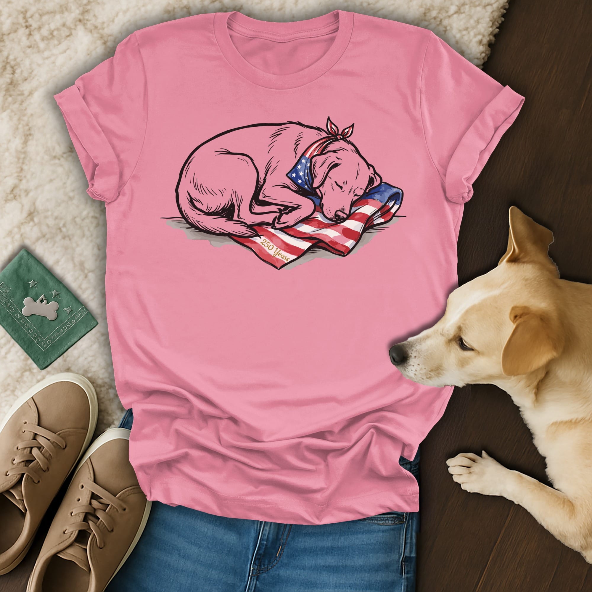 Pink t-shirt with sleeping dog on American flag, paired with jeans and sneakers.