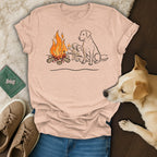 Two adult dogs and two puppies sit by a campfire.