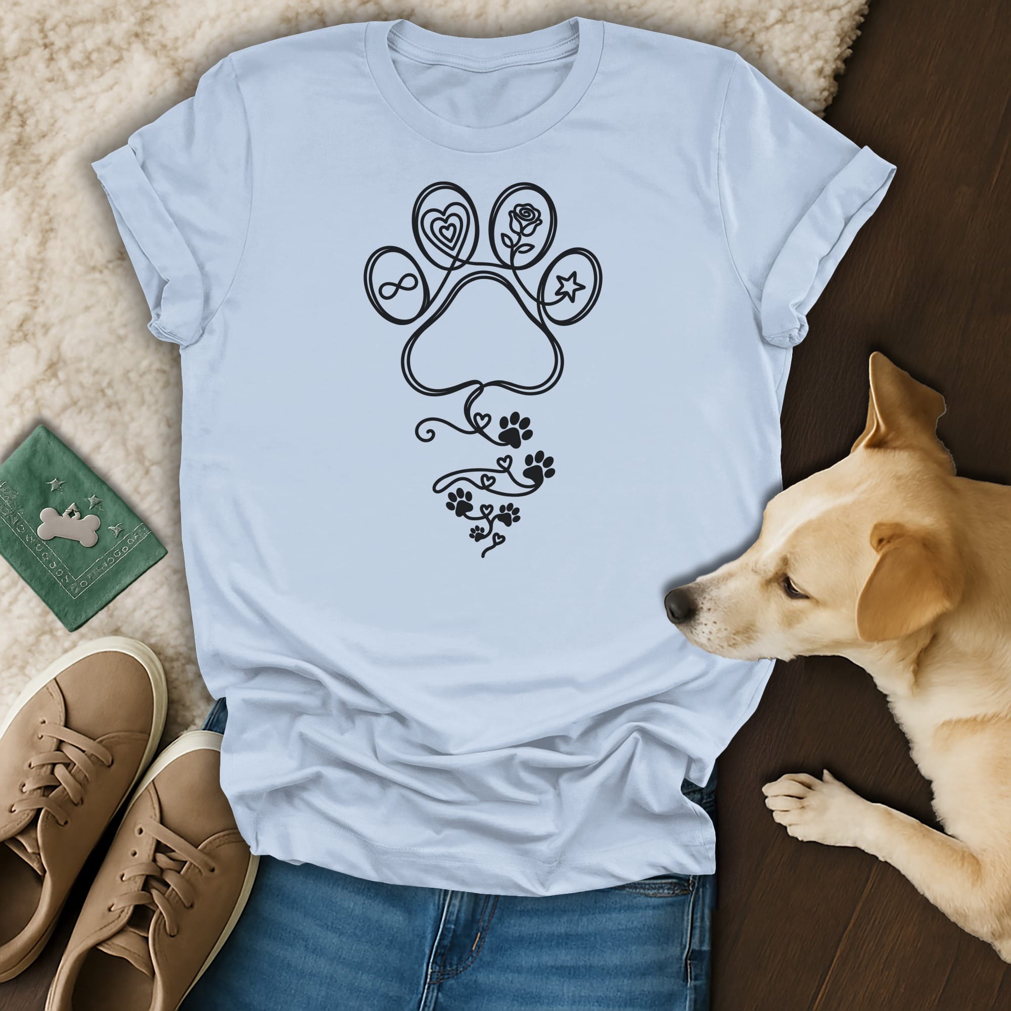 Light blue t-shirt with a black paw print design incorporating floral and heart elements.