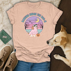 Peach t-shirt with a graphic of a dog in a ghost costume saying "Barking Under the Boo-n."