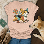Peach t-shirt with a colorful corgi holding a flower.