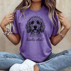 Purple t-shirt with a black doodle-style dog and "doodle what?" text.